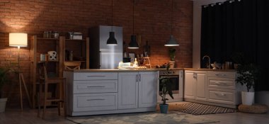 Geceleri mutfak tezgahları, raf üniteleri ve parlayan lambalarla dolu.