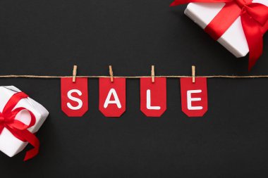 Hediye kutuları, halatlar, mandallar ve bayraklar. Siyah arka planda satışta.