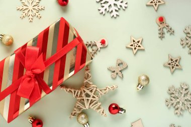 Noel hediyesi kutusu, tahta oyuncaklar ve yeşil arka planda toplar.