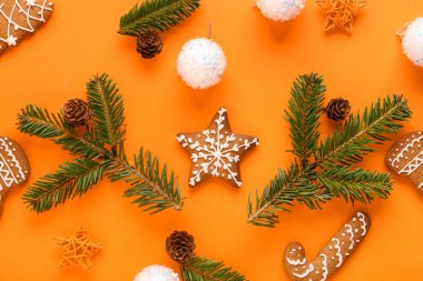 Noel kurabiyeleri, köknar dalları ve renk arkaplanı üzerindeki dekorasyonlarla kompozisyon