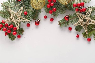 Işık arka planında köknar ağacı dalları, böğürtlen ve dekor bulunan Noel kompozisyonu