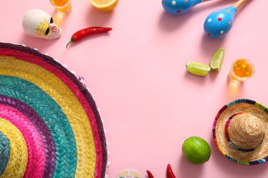 Meksika sombrerosundan yapılmış çerçeve, marakalar, tekila ve pembe arka planda limon. El Dia de Muertos