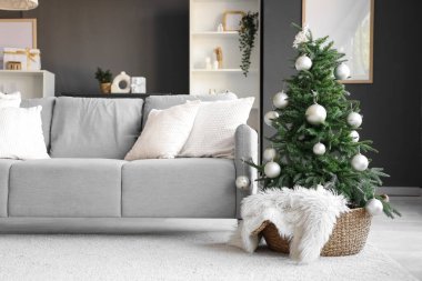 Oturma odasının içinde kanepe ve Noel ağacı var.