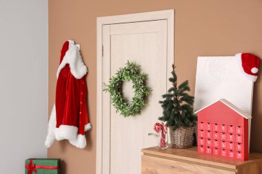 Kapısında Noel çelengi ve Noel Baba kostümü olan salon.