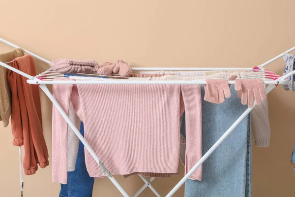 Bej arka planda kışlık giysileri olan kurutucu.