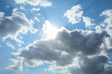 Güzel mavi gökyüzü manzarası, bulutların arkasında güneş var.