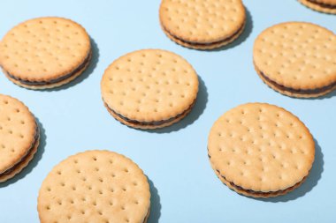 Mavi arka planda çikolata kremalı lezzetli sandviç bisküvileri