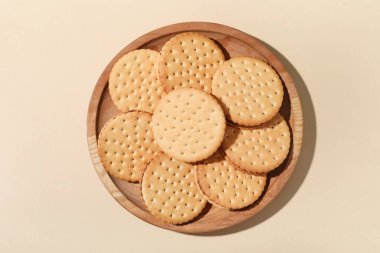 Bej arka planda lezzetli sandviç bisküvileri ile ahşap tabak