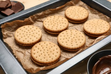 Lezzetli sandviç bisküvileri ve bir kase çikolatalı krema, yakın plan.