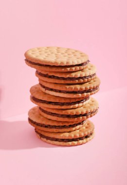 Pembe arka planda lezzetli sandviç bisküvileri.