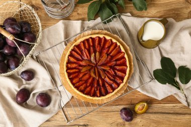 Lezzetli erikli turta, taze meyve sepeti ve tahtadan arka planda bir sürahi süt.