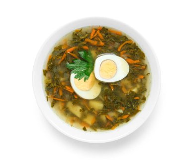 Beyaz arka planda maydanozlu yeşil borş çorbası.