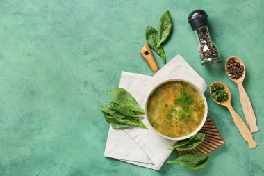 Bir kase lezzetli yeşil borş biber, yeşillik ve yeşil grunge arka planda ıspanak yaprağı.