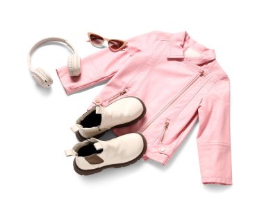 Pembe deri ceket, kulaklık, güneş gözlüğü ve beyaz arka planda botlar.
