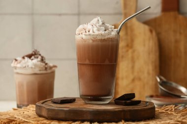 Krem şantili ve beyaz masadaki çikolatalı soğuk kakao bardakları