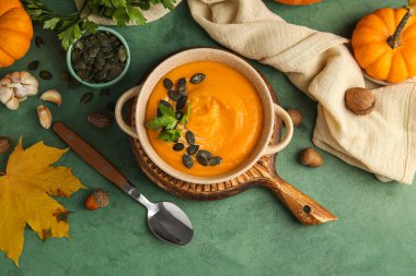 Yeşil arkaplanda lezzetli balkabağı kremalı çorba.