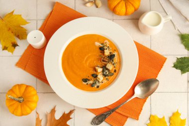 Beyaz fayanslı çekirdekli ve kızarmış ekmekli lezzetli kabak kremalı çorba tabağı.