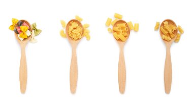 Beyaz arka planda farklı türde pişirilmemiş makarna içeren kaşıklar.