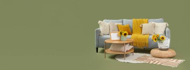 Ayçiçekli gri kanepe, masa ve yeşil arka planda puf.