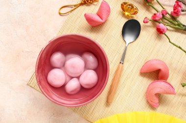 Bir kase Tangyuan, fal kurabiyeleri ve bej arka planda sakura. Dongzhi Festivali