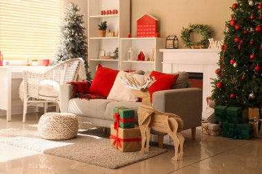 Oturma odasının içinde Noel dekoru olan rahat bir kanepe ve işyeri.