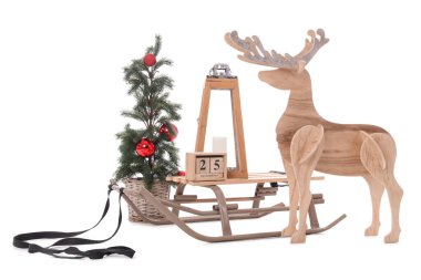 Tahta geyik, fener, Noel ağacı ve beyaz arka planda izole edilmiş küp takvimi olan bir kızak.