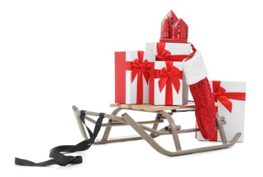 Hediye kutularıyla kızak, Noel Baba çorabı ve beyaz arka planda izole edilmiş ev şeklindeki fener.