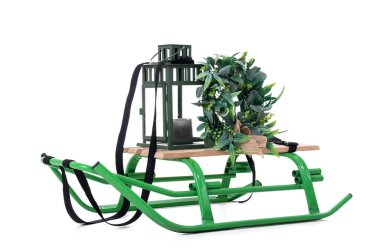 Beyaz arka planda izole edilmiş fener ve Noel çelengi ile kızak