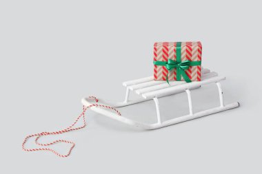 Beyaz arkaplanda hediye kutusuyla kızak