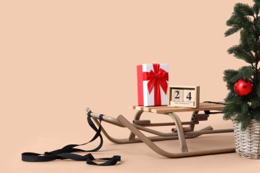 Saksıda Noel ağacı, hediye kutusu ve takvim bej arka planda, yakın plan