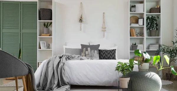 Ev bitkileriyle dolu rahat bir yatak odası.