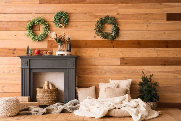 İçinde Noel çelenkleri, şömine rafı ve yastıklar olan oturma odası.