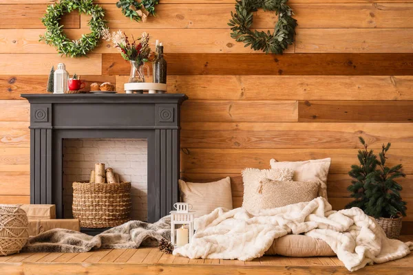 İçinde Noel çelenkleri, şömine rafı ve yastıklar olan oturma odası.