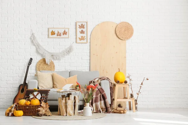 Oturma odasının içinde kanepe, piknik sepeti ve sonbahar dekoru var.