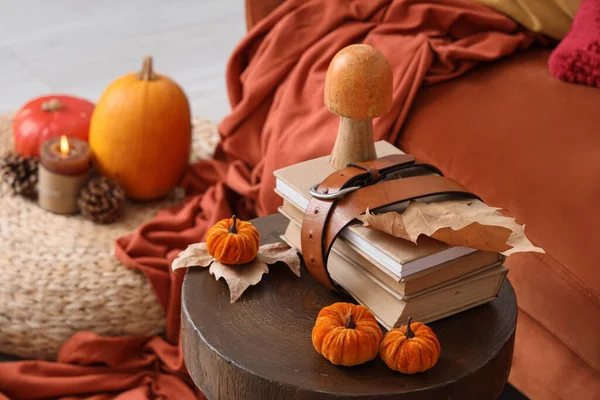 Oturma odasında sonbahar yapraklı, balkabaklı ve mantarlı kitaplar.