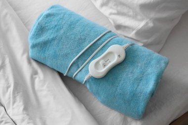 Katlanmış elektrikli ısıtma yastığı, yatak odası, üst manzara.