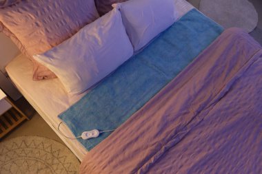 Modern elektrikli ısıtma yastığı gece yatak odasında, üst manzara.