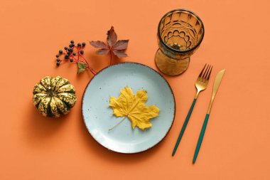 Güz yaprakları ve turuncu arka planda balkabağı ile güzel bir masa.