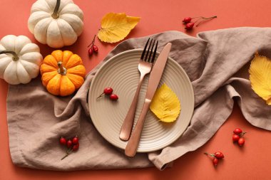 Güz yaprakları, balkabakları ve kırmızı arka planda gül böğürtlenleri olan güzel bir masa.