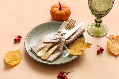 Güz yaprakları, balkabağı ve bej arka planda gül böğürtlenleri ile güzel bir masa, yakın plan.