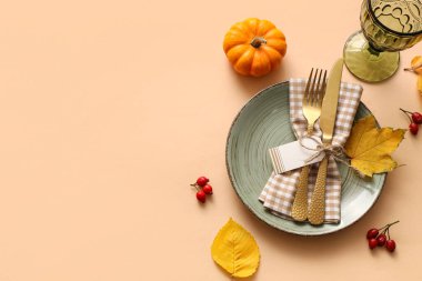 Sonbahar yaprakları, balkabağı ve bej arkaplanda gül kalçası çilekleri ile güzel bir masa.