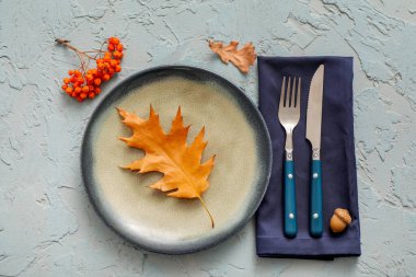 Sonbahar yaprakları, meşe palamudu ve açık mavi arka planda böğürtlenlerle güzel bir masa.