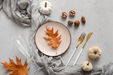 Sonbahar yaprakları, cevizler ve beyaz arka planda balkabaklarıyla güzel bir masa.