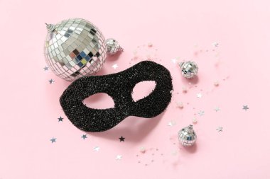 Siyah karnaval maskeli kompozisyon ve pembe arka planda disko topları