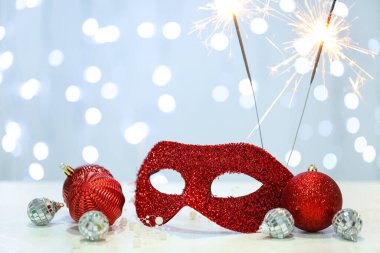 Kırmızı karnaval maskesi ve bulanık arka planda kıvılcımlar