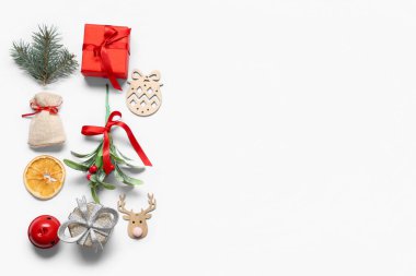 Noel süslemeleri, hediye kutusu ve beyaz arka planda ökseotu olan kompozisyon