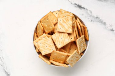 Beyaz arka planda lezzetli krakerler olan kase