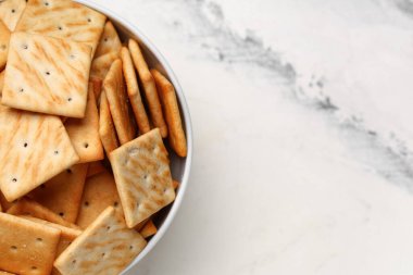 Beyaz arka planda lezzetli krakerler olan kase, yakın plan.