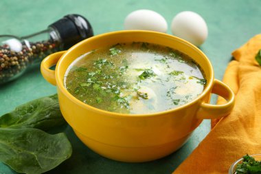 Yeşil grunge arka planında ıspanak yapraklı lezzetli yeşil borş çorbası.