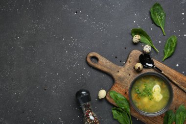 Yumurtalı, ıspanak yapraklı, biberli ve siyah grunge arkaplanlı bir kase lezzetli yeşil borş.